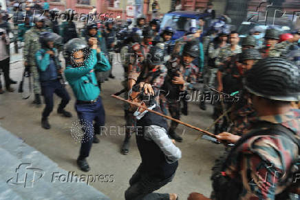 Law enforcers charge batons to disperse followers gathered to demand the release of their leader Chinmoy Krishna Das, at the Chattogram Metropolitan Magistrate Court, in Chattogram