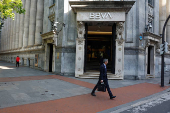 A man walks past a branch of Spain's BBVA bank in the Gran Via of Bilbao