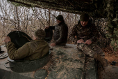 Servicemen prepare a howitzer to fire towards Russian troops at a frontline near the town of Chasiv Yar