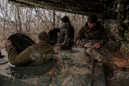 Servicemen prepare a howitzer to fire towards Russian troops at a frontline near the town of Chasiv Yar