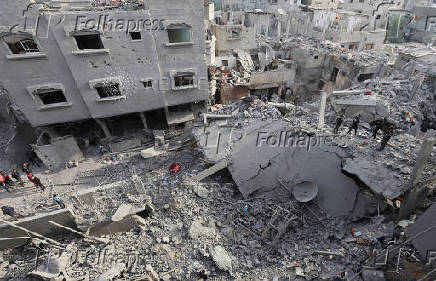 Palestinians inspect damage at the site of an Israeli strike on a house, at Nuseirat refugee camp