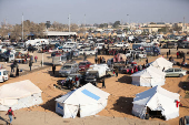 Displaced people who fled from Aleppo countryside, gather near tents in Tabqa