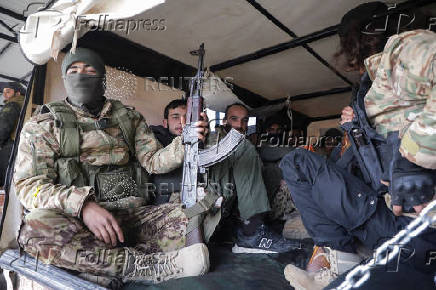 Rebel fighters sit together in Homs countryside