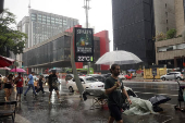 Pedestres enfrentam chuva na Avenida Paulsita, em So Paulo (SP)