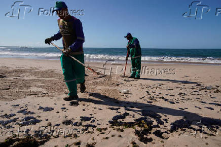 Agentes limpam manchas de leo na praia da Pituba, em Salvador (BA)