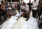 Mourners react next to the bodies of Palestinians killed in Israeli strikes, in Rafah
