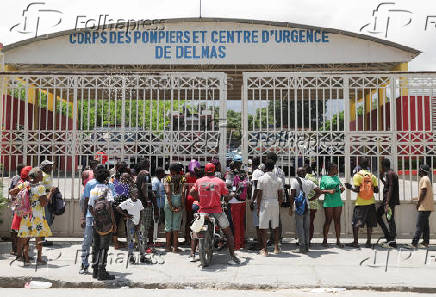People stand outside a fire station after hearing that donated food would be distributed, in Port-au-Prince