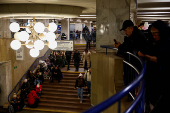 People take shelter inside a metro station during a Russian military strike, in Kyiv