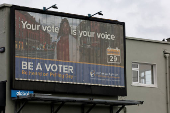 A sign encouraging people to vote is displayed on a building, in Greystones