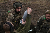 Policemen of the 'Khyzhak' Brigade place a shell into a mortar as they fire towards Russian troops at their position in a front line near the town of Toretsk