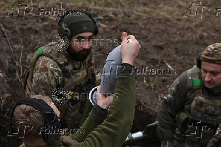 Policemen of the 'Khyzhak' Brigade place a shell into a mortar as they fire towards Russian troops at their position in a front line near the town of Toretsk