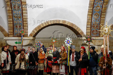 People dressed in traditional clothes sing carols inside a metro in Kyiv