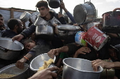 Displaced Palestinians collect donated food in Khan Yunis, southern Gaza