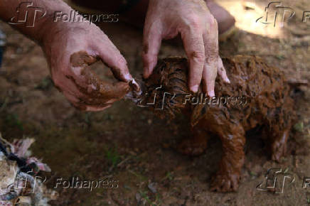 Homem limpa cachorro sujo de lama