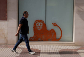 A man walks past a ING bank branch office in Malaga