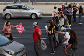People attempt to block traffic during a protest on the main highway connecting Jerusalem and Tel Aviv