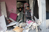 Palestinians inspect damage at the site of an Israeli strike on a house, at Nuseirat refugee camp