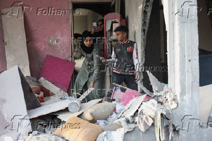 Palestinians inspect damage at the site of an Israeli strike on a house, at Nuseirat refugee camp