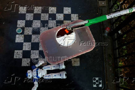 Outreach Public and Safety team members from OnPoint NYC pick up syringes from a sidewalk in the Bronx borough of New York City