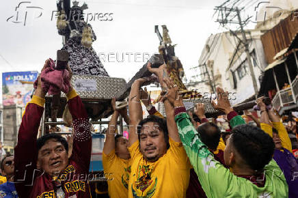 Filipino Catholics participate in the parade of Black Nazarene replicas