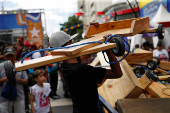 Government supporters participate in a traditional street race with wooden makeshift carts called 