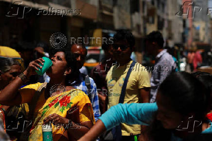 A woman drinks curd to cool herself down during a hot day in Bengaluru