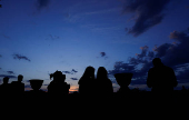 Silhouettes of people are seen at sunset in Rome