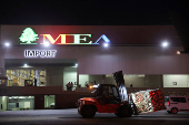 A Lebanese forklift driver moves palettes of aid delivered by United Arab Emirates to Lebanon, at Beirut International Airport,