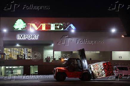 A Lebanese forklift driver moves palettes of aid delivered by United Arab Emirates to Lebanon, at Beirut International Airport,