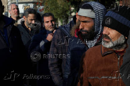 Former members of Syria's Bashar Al Assad's security forces wait to register for the identification and reconciliation process, in Damascus