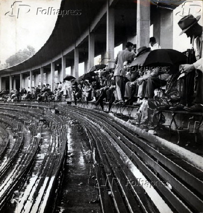 1955Torcedores debaixo de chuva no