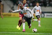 Vagner Love, do Corinthians, carrega a bola observado por Ganso, do Fluminense 