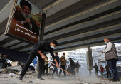 Members of Imam al-Mahdi scouts clean rubble and debris from damaged buildings in Beirut's southern suburbs