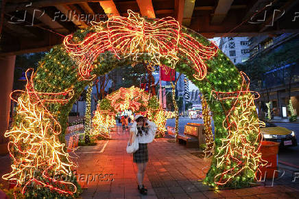 A woman poses for pictures at a Christmas theme park in New Taipei City