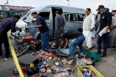 Members of the Crime Scene Unit and police officers survey the site after a suicide blast in Karachi