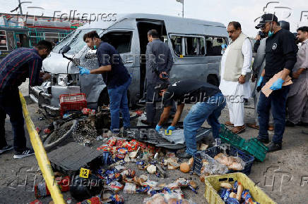 Members of the Crime Scene Unit and police officers survey the site after a suicide blast in Karachi