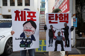 People hold posters ahead of a rally calling for the impeachment of South Korean President Yoon Suk Yeol, in Seoul