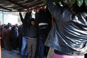 Former members of Syria's Bashar Al Assad's security forces wait to register for the identification and reconciliation process, in Damascus