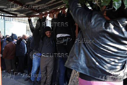 Former members of Syria's Bashar Al Assad's security forces wait to register for the identification and reconciliation process, in Damascus