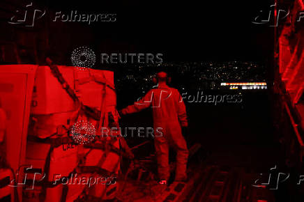 A United Arab Emirates military member stands next to palettes  at Beirut International Airport