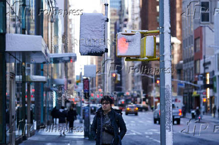 A person waits to cross the road, in New York