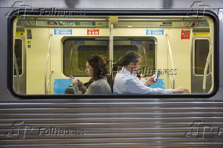 Passageiros usam o celular dentro do metr