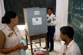 A policewoman casts her postal ballot at a polling station in Agartala