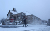 A man clears snow at the Church of Scotland in Pitlochry, Scotland