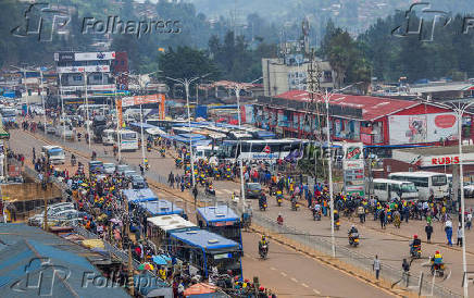 Motorists and motorcyclists move along a street in the outskirts Kigali