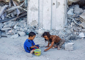 FILE PHOTO: Palestinian children play outside the rubble of a house destroyed in Israeli strikes, amid the Israel-Hamas conflict, in Khan Younis in the the southern Gaza Strip