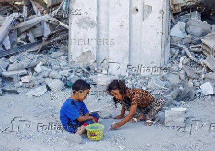 FILE PHOTO: Palestinian children play outside the rubble of a house destroyed in Israeli strikes, amid the Israel-Hamas conflict, in Khan Younis in the the southern Gaza Strip