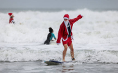 Surfing Santas take to the waves at the annual Christmas Eve event in Cocoa Beach