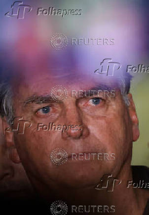 Brazil's former President Jair Bolsonaro talks with media upon his arrival at Brasilia International Airport