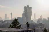 A visitor stands in front of Grand Lisboa casino operated by SJM Holdings, in Macau